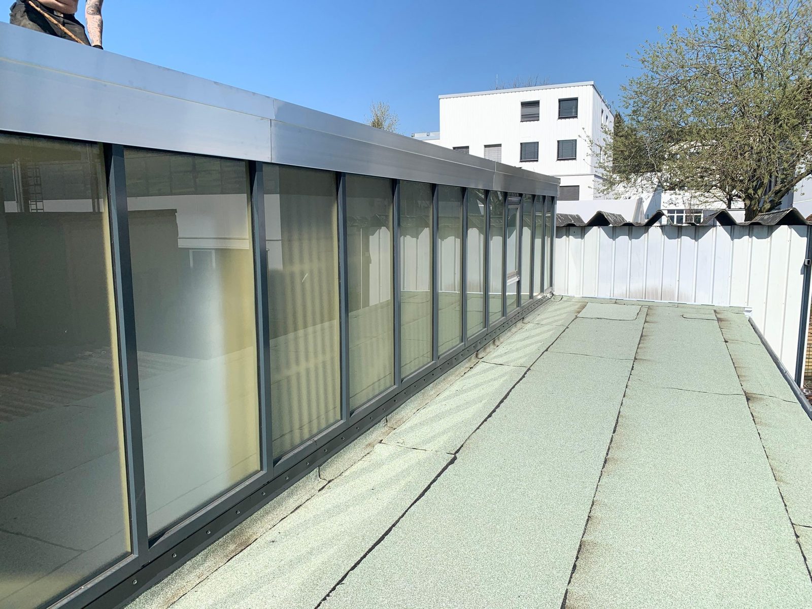 Langgestrecktes Metall- und Glasdach eines Gewerbebaus